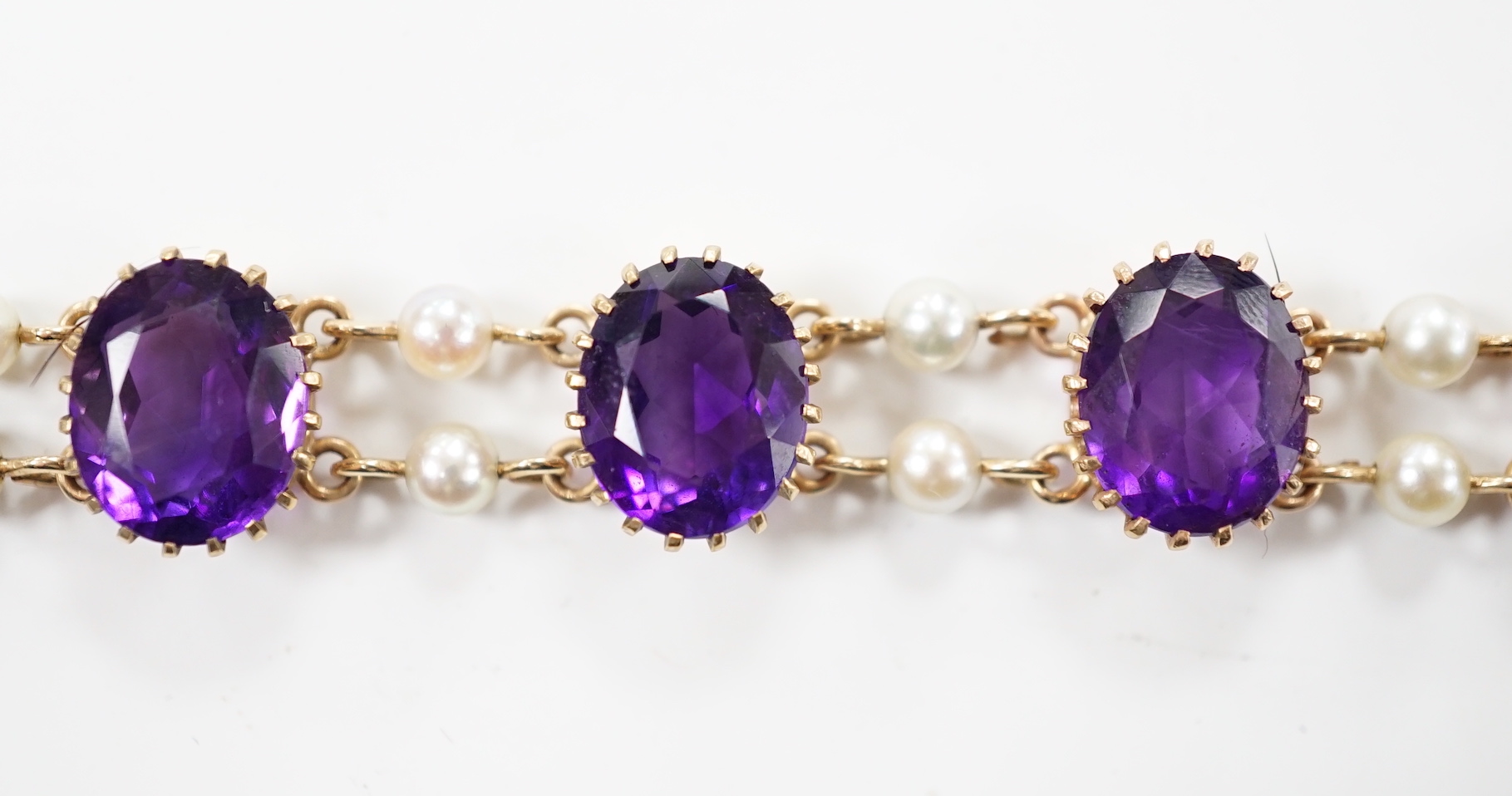 A 1970's Edwardian style 9ct gold amethyst and cultured pearl cluster set bracelet, 17.5cm, gross weight 15.9 grams.